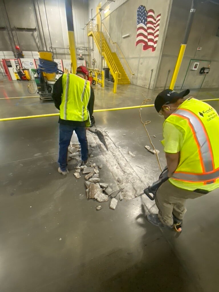 workers filling cracks in concrete