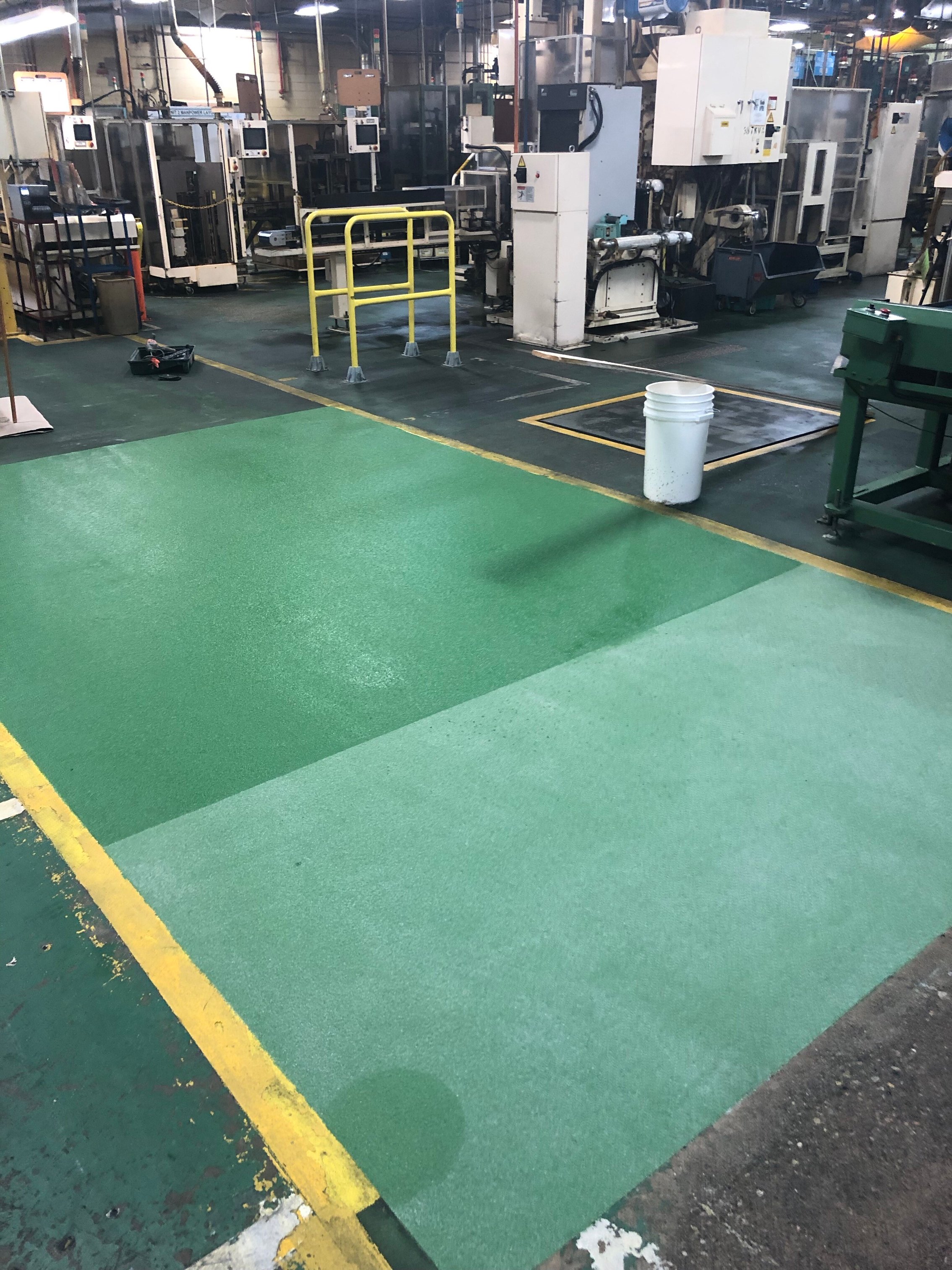 factory floor with green urethane cement floor coating and safety lines