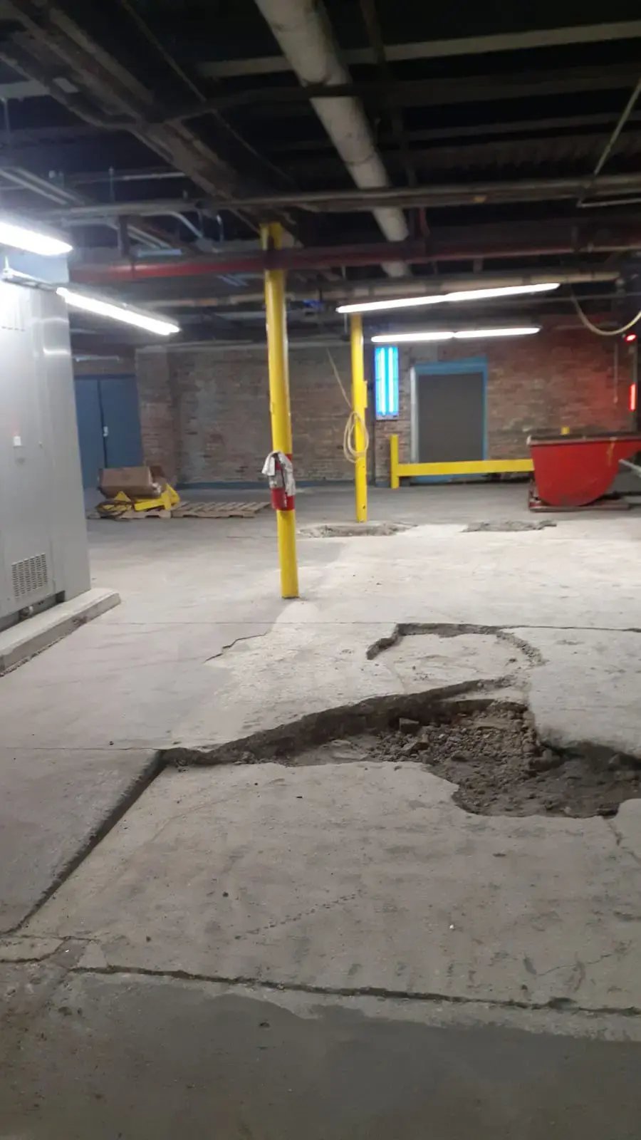 Concrete Repair - Before photo showing a very large crack in concrete in a warehouse