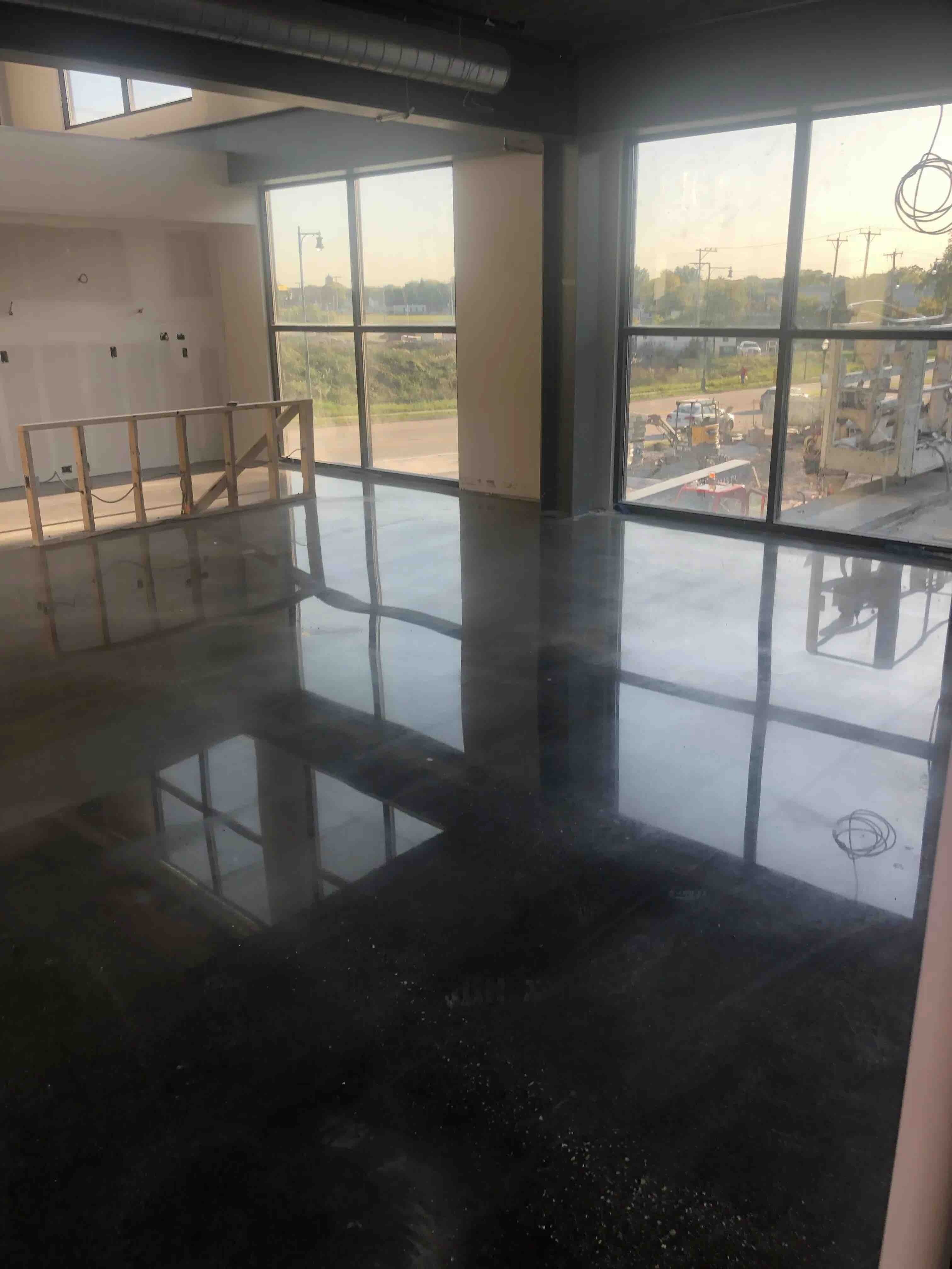 Polished Concrete floor looking out onto large floor to ceiling windows