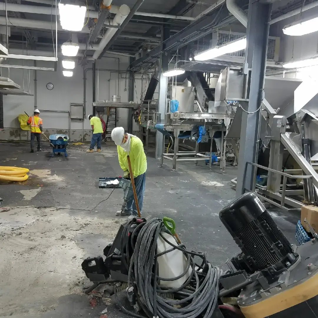 Concrete Prep done by customcrete workers holding a jackhammer and wearing helmet