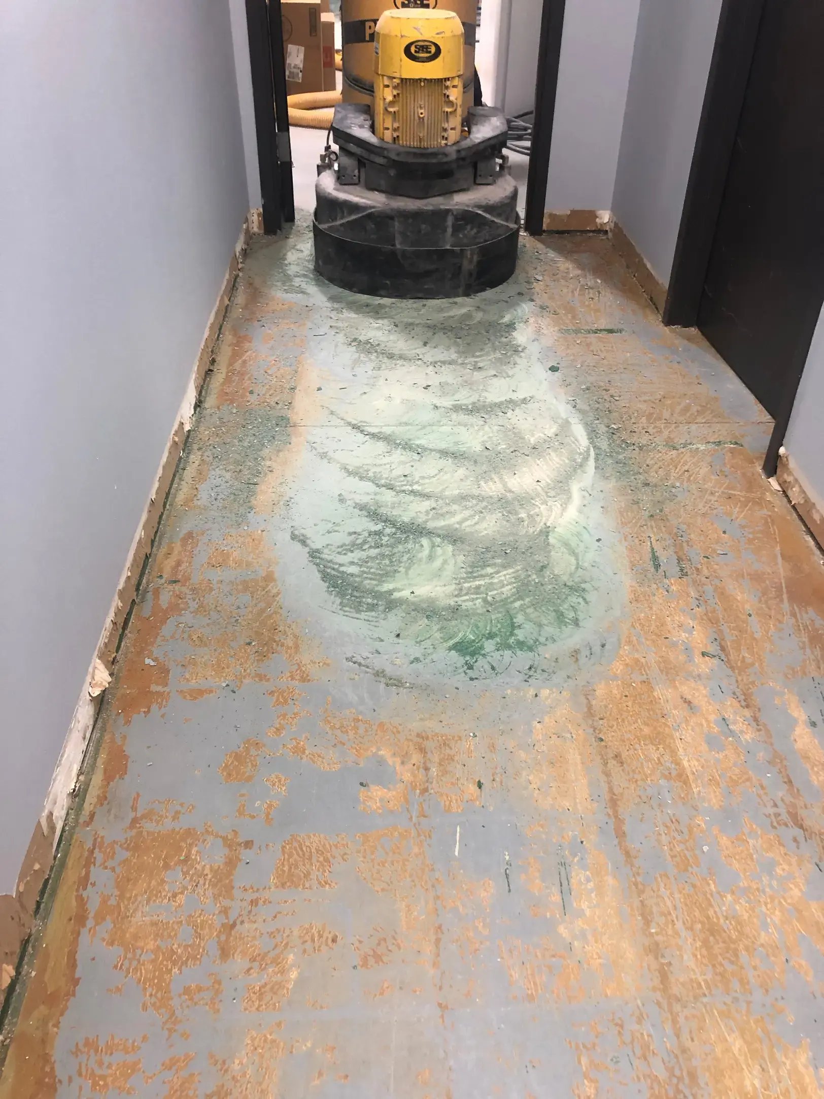 grinding old concrete coating in a hallway