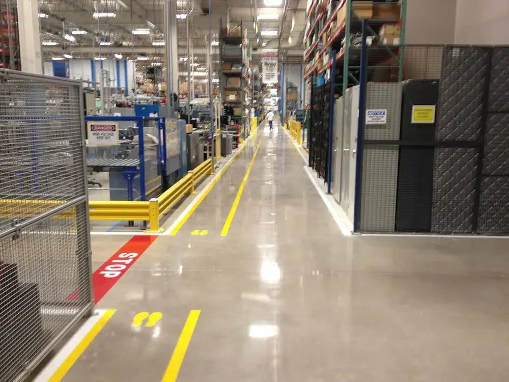 worker walks through walkways with Linestriping in. a large manufacturing plant in chicagoland 