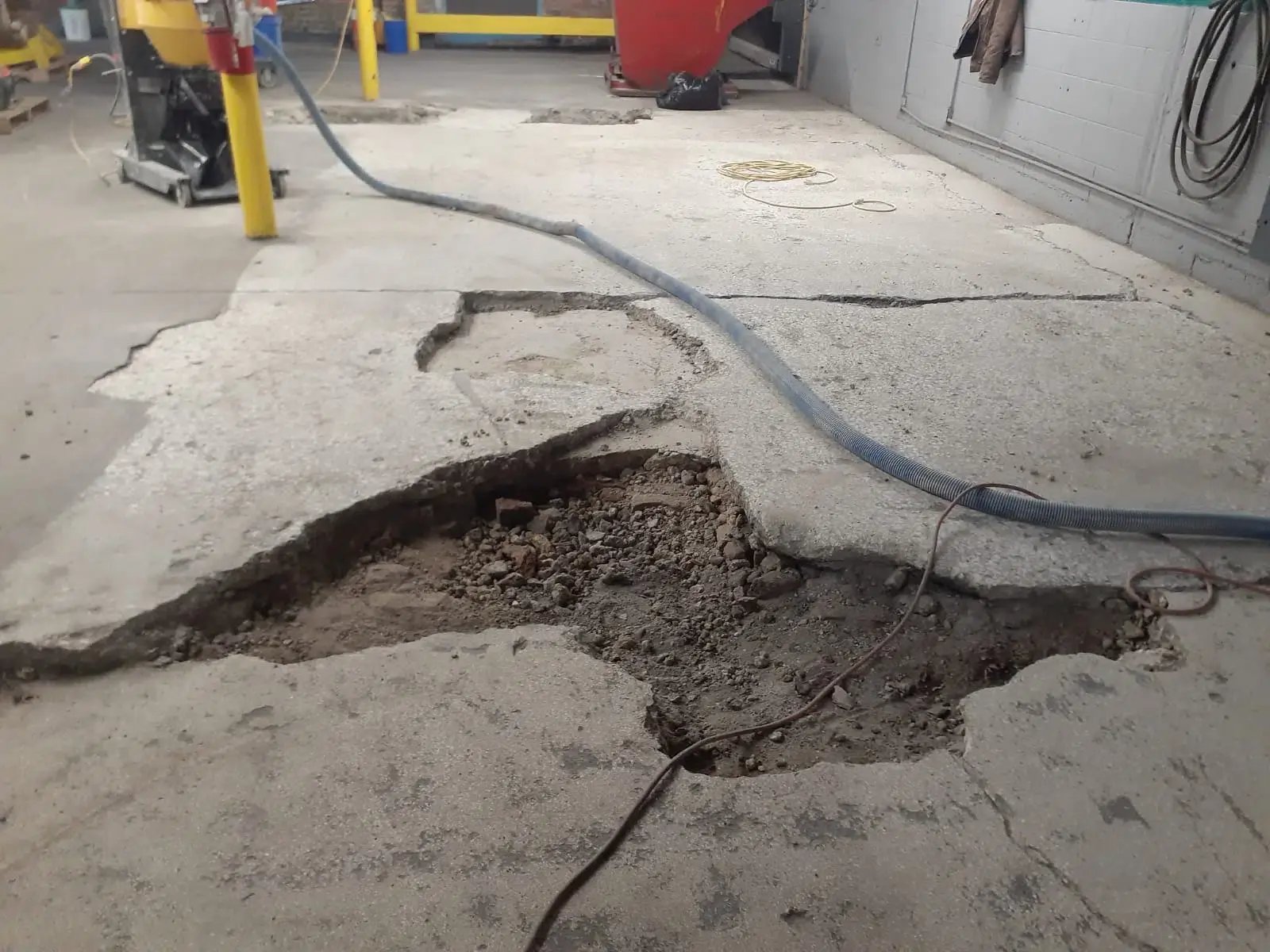 large crack in a concrete floor being readied for Concrete Repair services by customcrete