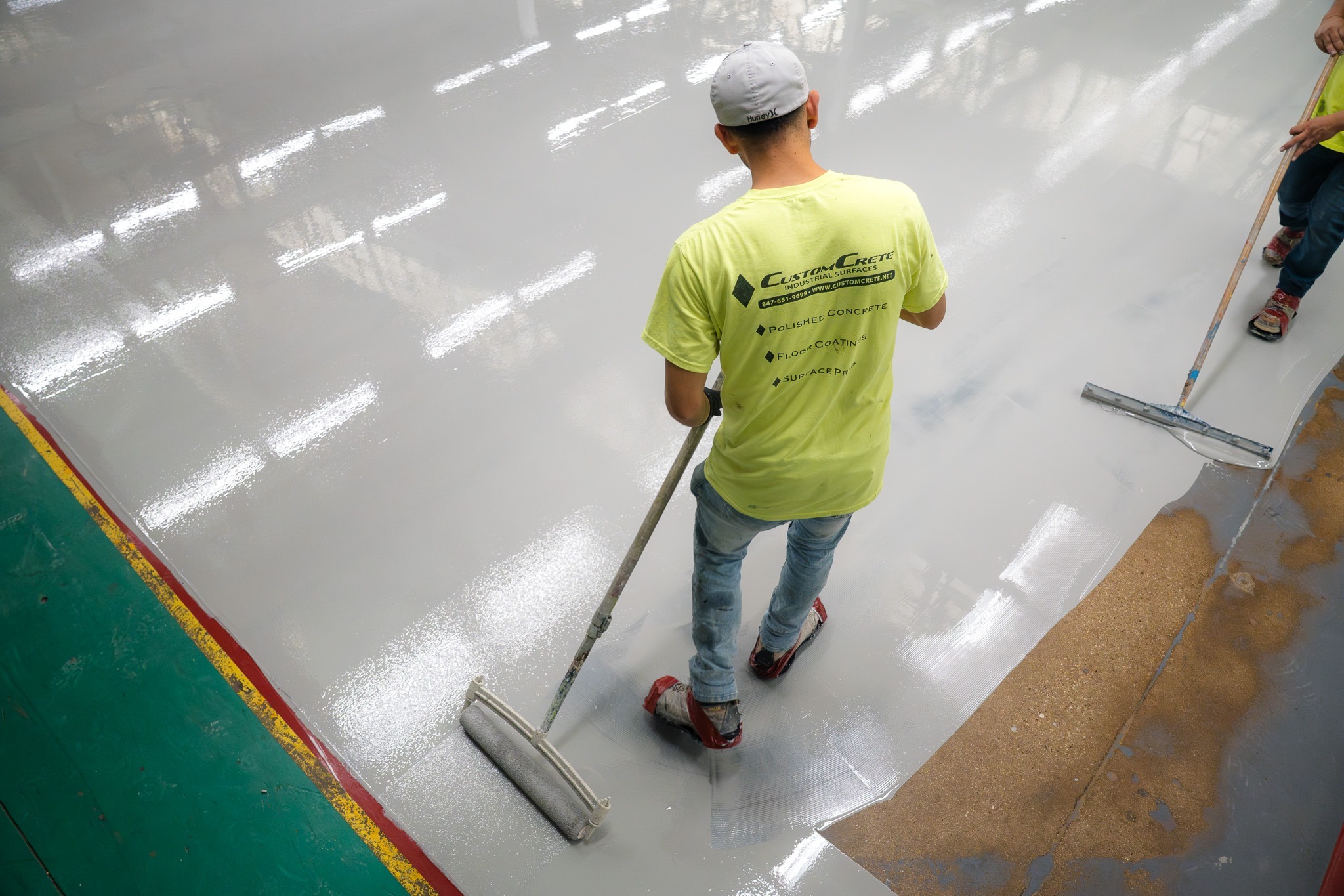 CustomCrete team applying epoxy flooring